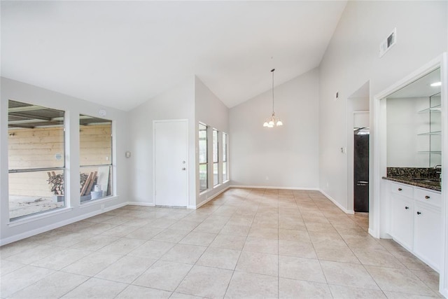 interior space featuring white cabinets, an inviting chandelier, high vaulted ceiling, light tile patterned floors, and visible vents