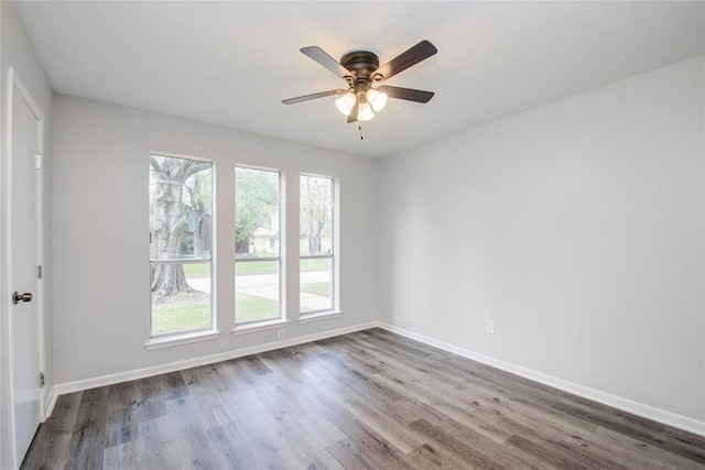 spare room with baseboards, a ceiling fan, and wood finished floors