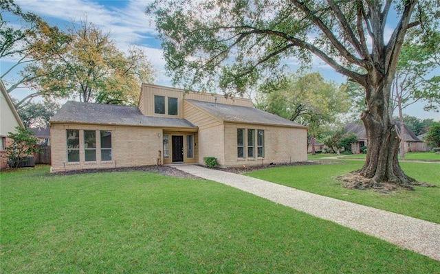 mid-century inspired home featuring brick siding and a front lawn