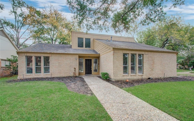 view of front of home featuring brick siding and a front lawn