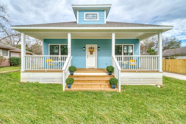 bungalow-style home featuring fence, a shingled roof, a porch, and a front yard