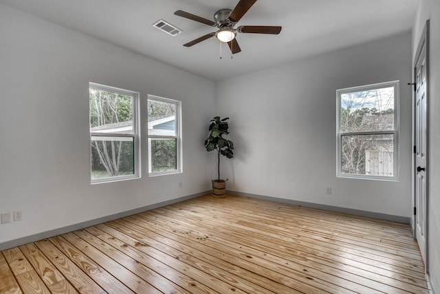 unfurnished room with a ceiling fan, baseboards, visible vents, and hardwood / wood-style floors