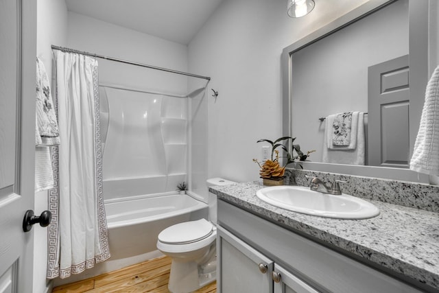 bathroom with vanity, wood finished floors, toilet, and shower / tub combo