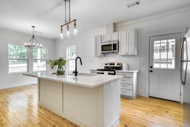 kitchen with visible vents, light wood-style floors, light countertops, a sink, and appliances with stainless steel finishes