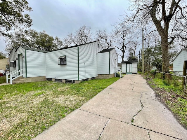 1827 Neuman St, La Marque, TX 77568 - view of property exterior featuring a lawn, fence, an outdoor structure, a shed, and entry steps