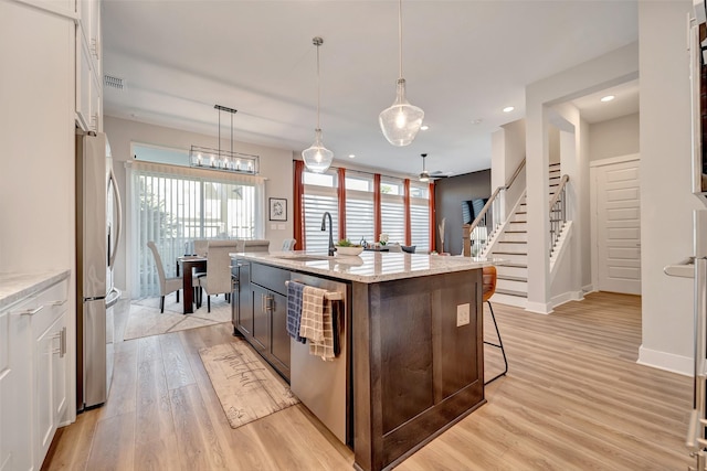 kitchen featuring visible vents, appliances with stainless steel finishes, light wood-type flooring, a sink, and white cabinetry