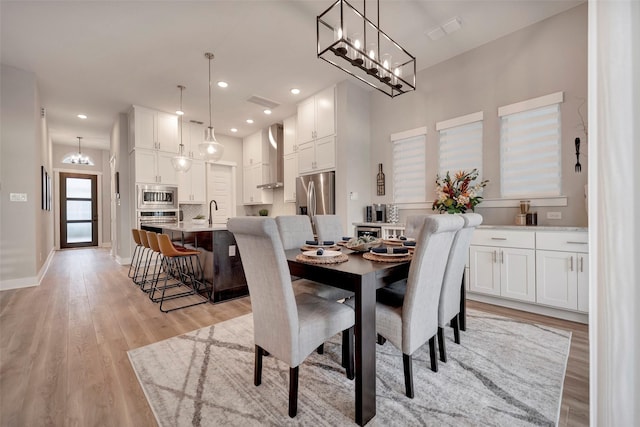 dining room with visible vents, baseboards, recessed lighting, light wood-style flooring, and a notable chandelier