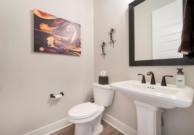 bathroom featuring baseboards, toilet, and wood finished floors