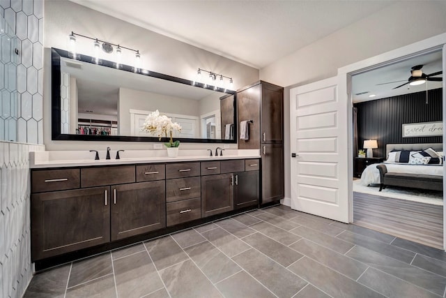 ensuite bathroom featuring double vanity, a ceiling fan, visible vents, a sink, and ensuite bathroom