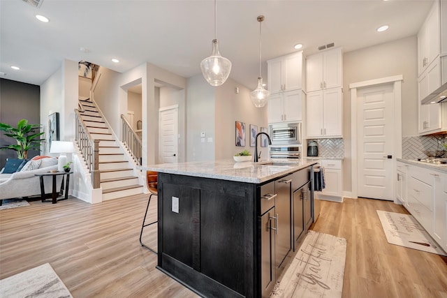 kitchen with white cabinetry, recessed lighting, decorative backsplash, and a sink