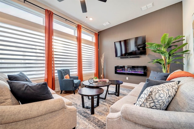 living room featuring visible vents, ceiling fan, and wood finished floors