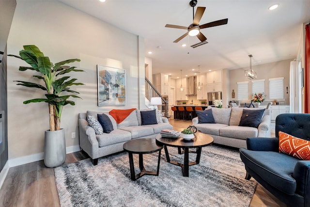 living room with a ceiling fan, visible vents, wood finished floors, baseboards, and recessed lighting