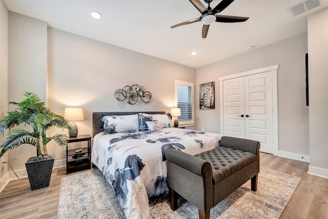 bedroom featuring ceiling fan, baseboards, light wood-type flooring, visible vents, and a closet