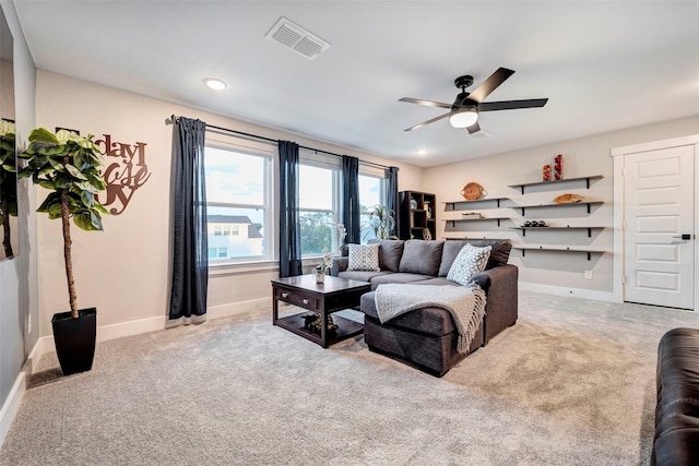 living room featuring ceiling fan, visible vents, baseboards, and carpet