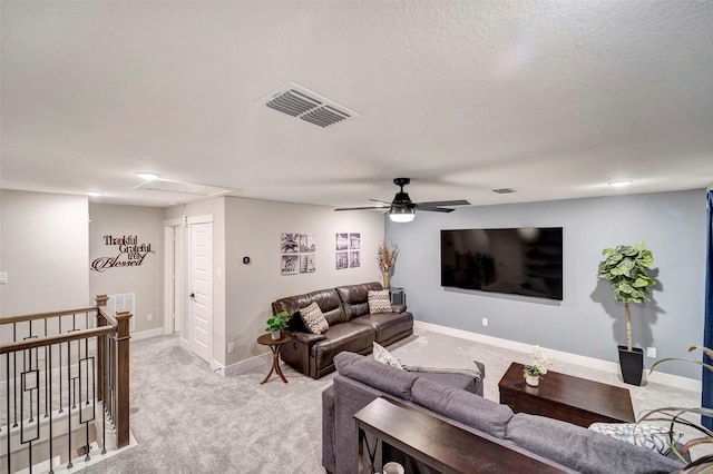 living room with baseboards, ceiling fan, light colored carpet, and visible vents