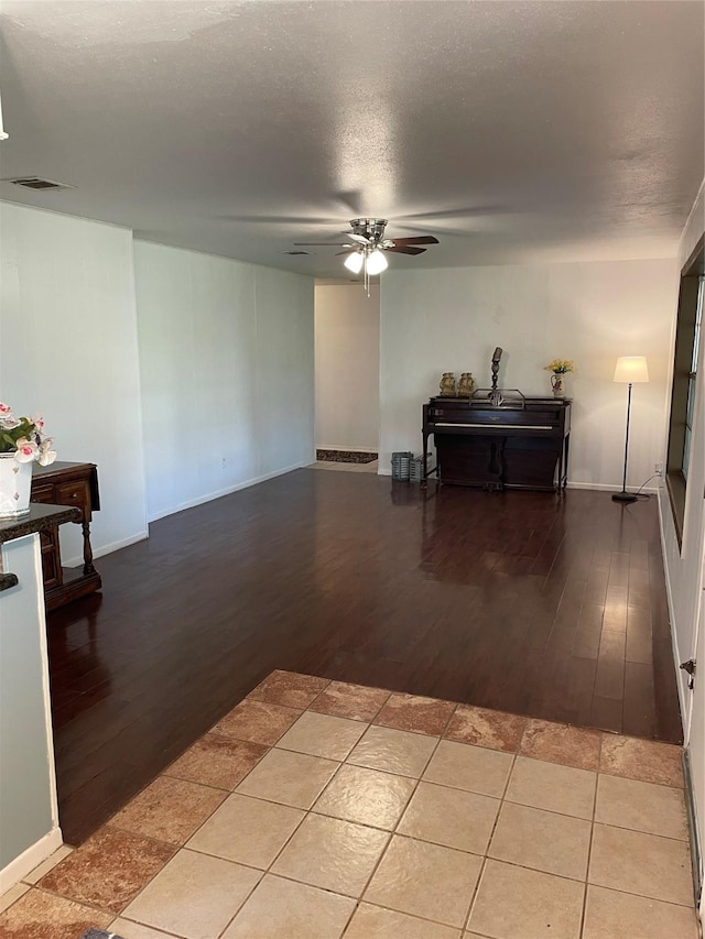 living room featuring ceiling fan, light wood finished floors, and baseboards