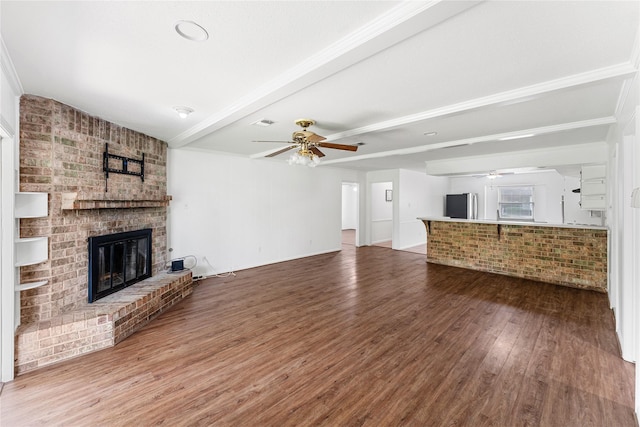7226 Brook Stone Dr, Houston, TX 77040 - unfurnished living room featuring ceiling fan, visible vents, a brick fireplace, wood finished floors, and beamed ceiling