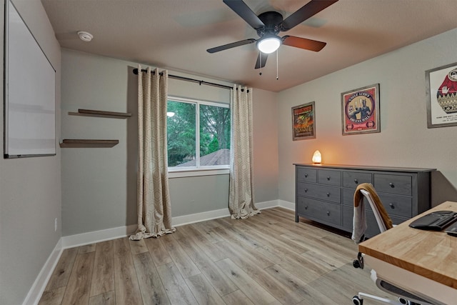 office space featuring light wood finished floors, a ceiling fan, and baseboards