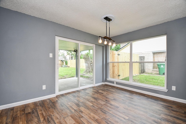 unfurnished dining area featuring baseboards, a healthy amount of sunlight, and wood finished floors