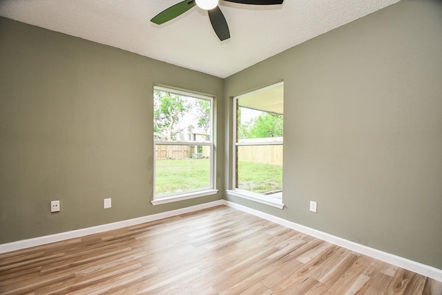 spare room with baseboards, light wood-style flooring, and ceiling fan