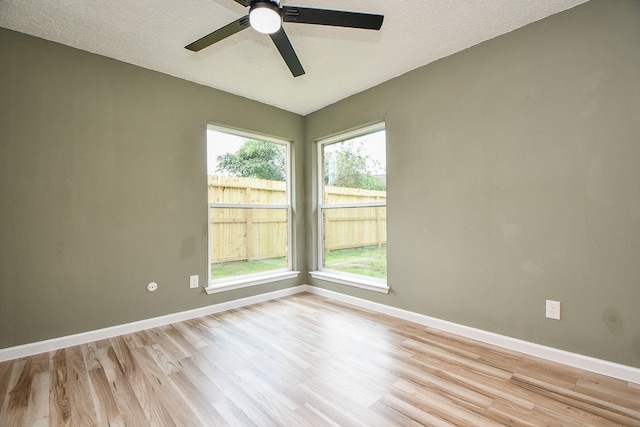 empty room featuring ceiling fan, light wood-style flooring, and baseboards