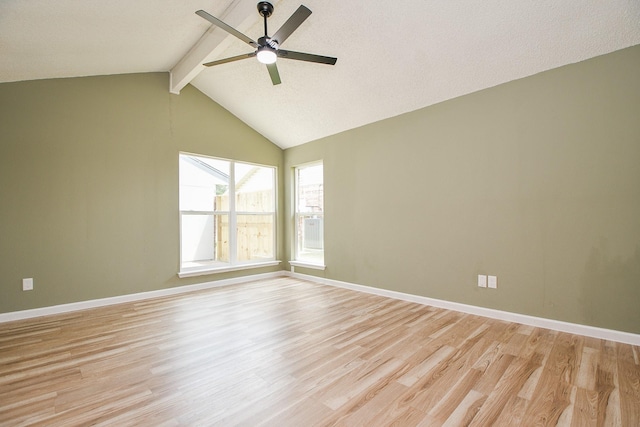 spare room featuring light wood finished floors, baseboards, ceiling fan, and vaulted ceiling with beams