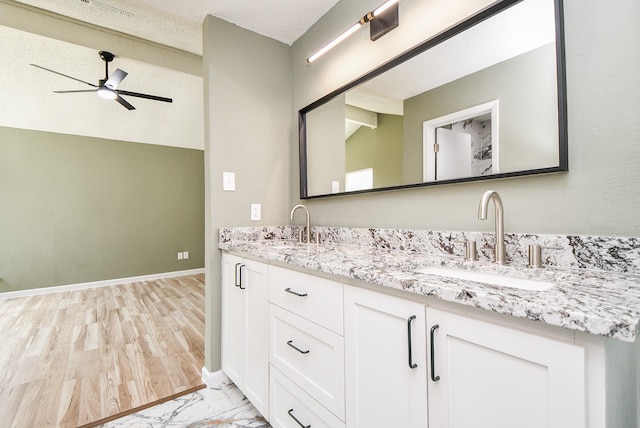 full bath with marble finish floor, ceiling fan, a sink, and double vanity