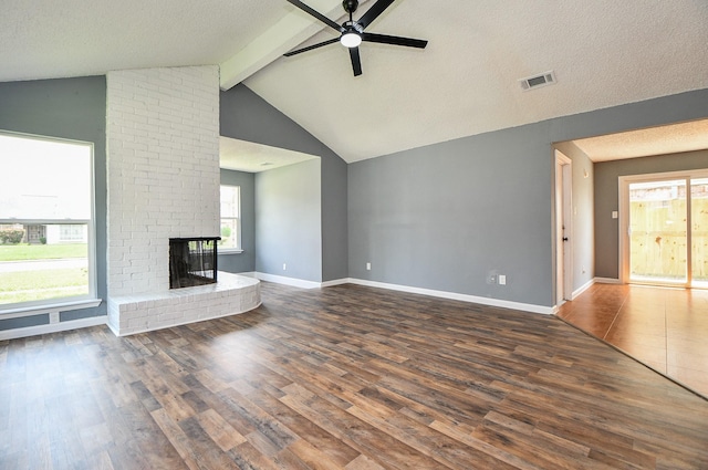 unfurnished living room featuring wood finished floors, a ceiling fan, a brick fireplace, visible vents, and baseboards