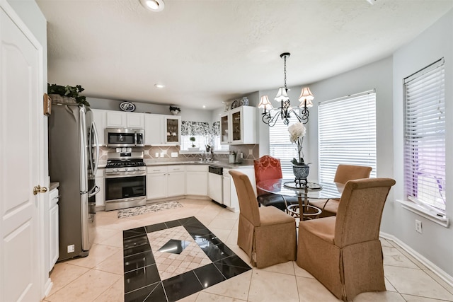 dining area featuring light tile patterned flooring, a chandelier, and recessed lighting