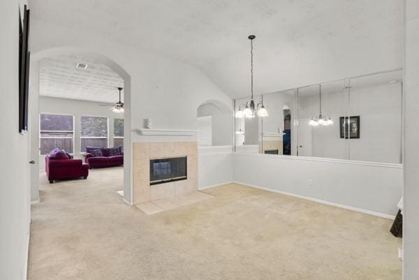 4526 Cannongate Dr, Spring Branch, TX 77373 - unfurnished living room with ceiling fan, arched walkways, carpet, a fireplace, and vaulted ceiling
