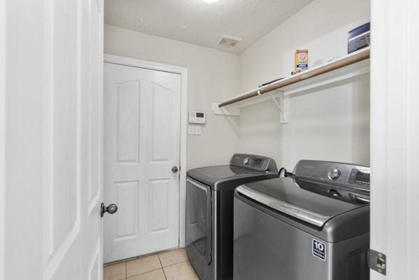 4526 Cannongate Dr, Spring Branch, TX 77373 - laundry room with washer and clothes dryer and light tile patterned flooring