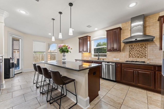 31183 Pecan Creek Dr, Brookshire, TX 77423 - kitchen with wall chimney range hood, a kitchen island, appliances with stainless steel finishes, tasteful backsplash, and a sink