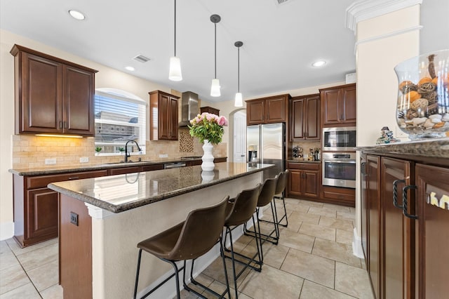 31183 Pecan Creek Dr, Brookshire, TX 77423 - kitchen with appliances with stainless steel finishes, a sink, arched walkways, tasteful backsplash, and a kitchen island