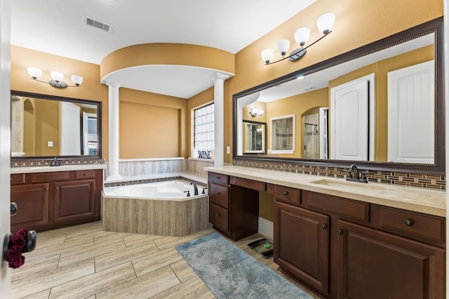 31183 Pecan Creek Dr, Brookshire, TX 77423 - bathroom with a sink, decorative columns, wood finished floors, visible vents, and a garden tub