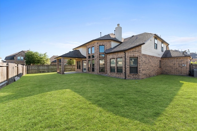 31183 Pecan Creek Dr, Brookshire, TX 77423 - back of property with a yard, brick siding, a fenced backyard, and roof with shingles