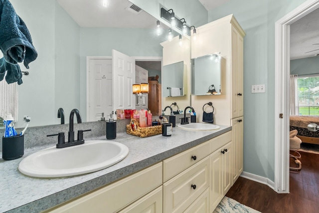 14854 Altair Ct, Willis, TX 77318 - ensuite bathroom with visible vents, a sink, wood finished floors, and double vanity