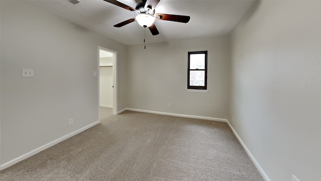 empty room with a ceiling fan, baseboards, and light colored carpet