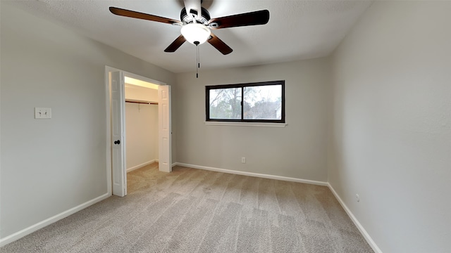 unfurnished bedroom with light colored carpet, a ceiling fan, baseboards, and a closet