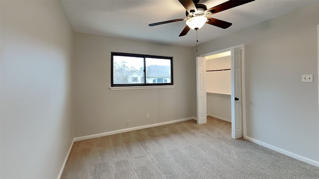 unfurnished bedroom featuring carpet floors, a ceiling fan, and baseboards