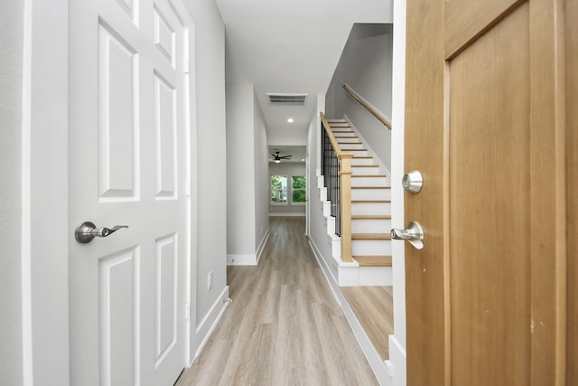 foyer featuring baseboards, stairs, light wood-style flooring, and visible vents