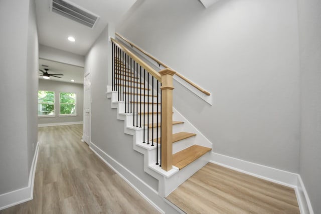 stairway with visible vents, a ceiling fan, baseboards, and wood finished floors