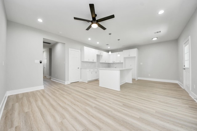 unfurnished living room with ceiling fan, light wood finished floors, recessed lighting, baseboards, and visible vents