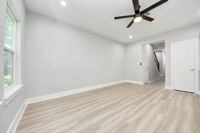 empty room featuring recessed lighting, baseboards, a wealth of natural light, and light wood-style flooring