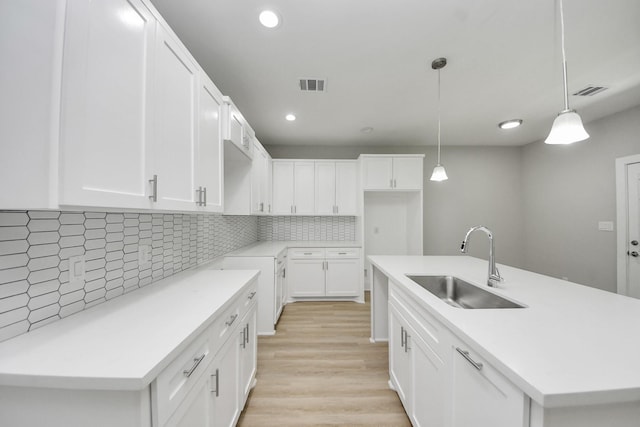 kitchen featuring a sink, a kitchen island with sink, recessed lighting, decorative backsplash, and visible vents