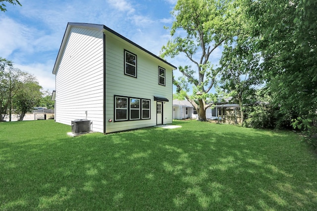 rear view of house with a lawn and central AC unit