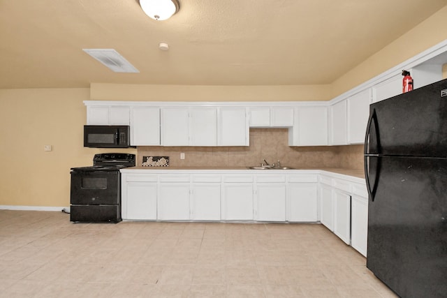 kitchen featuring white cabinets, a sink, light countertops, baseboards, and black appliances