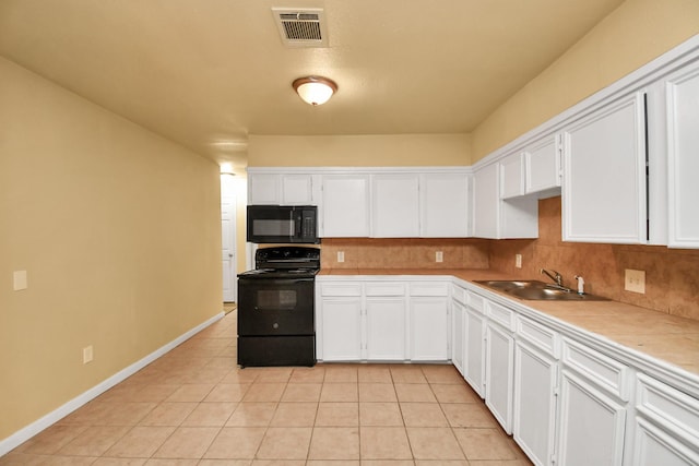 kitchen featuring white cabinets, visible vents, a sink, and black appliances