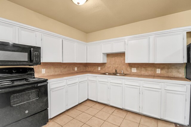kitchen featuring white cabinets, light tile patterned flooring, a sink, light countertops, and black appliances