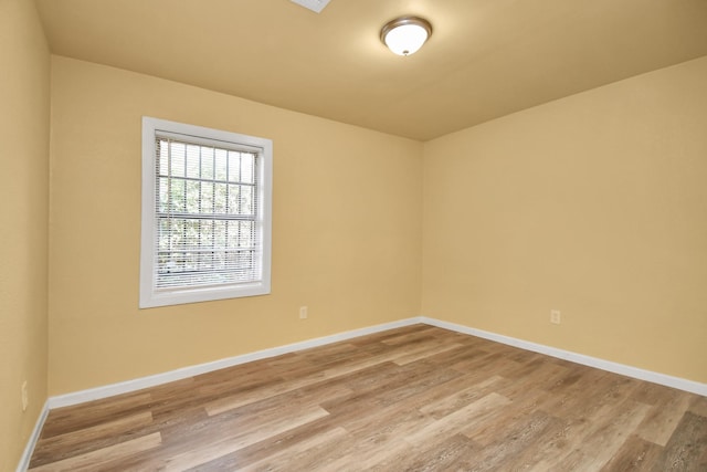 empty room featuring baseboards and light wood-style floors
