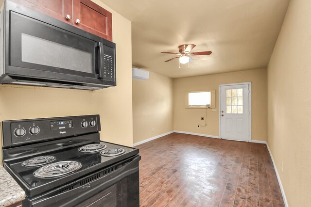 kitchen featuring ceiling fan, a wall mounted air conditioner, baseboards, wood finished floors, and black appliances